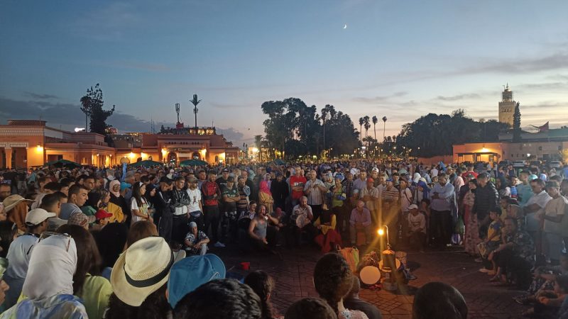 A crowd of people watching musicians in Jemaa el-Fnaa, Marrakech